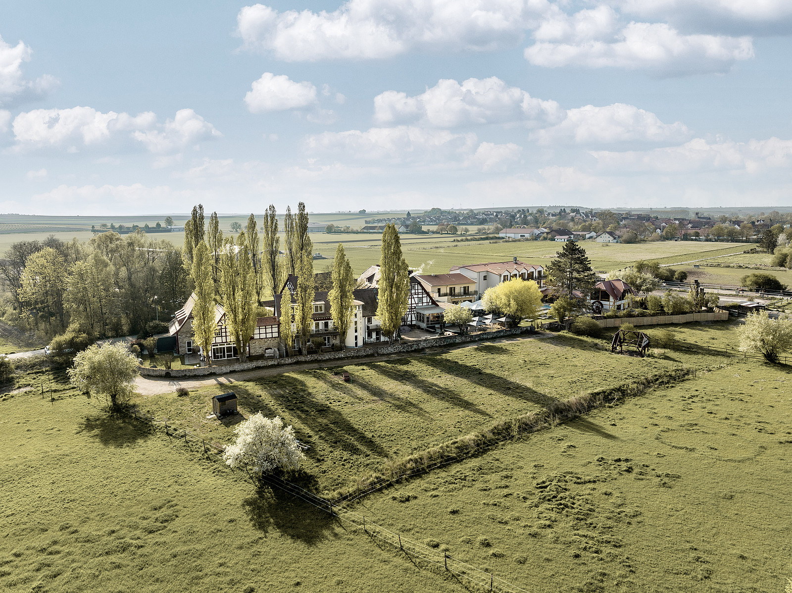 Luftaufnahme von Jordan's Untermühle, dem Wellnesshotel in Rheinhessen, umgeben von Wiesen, Feldern und Natur