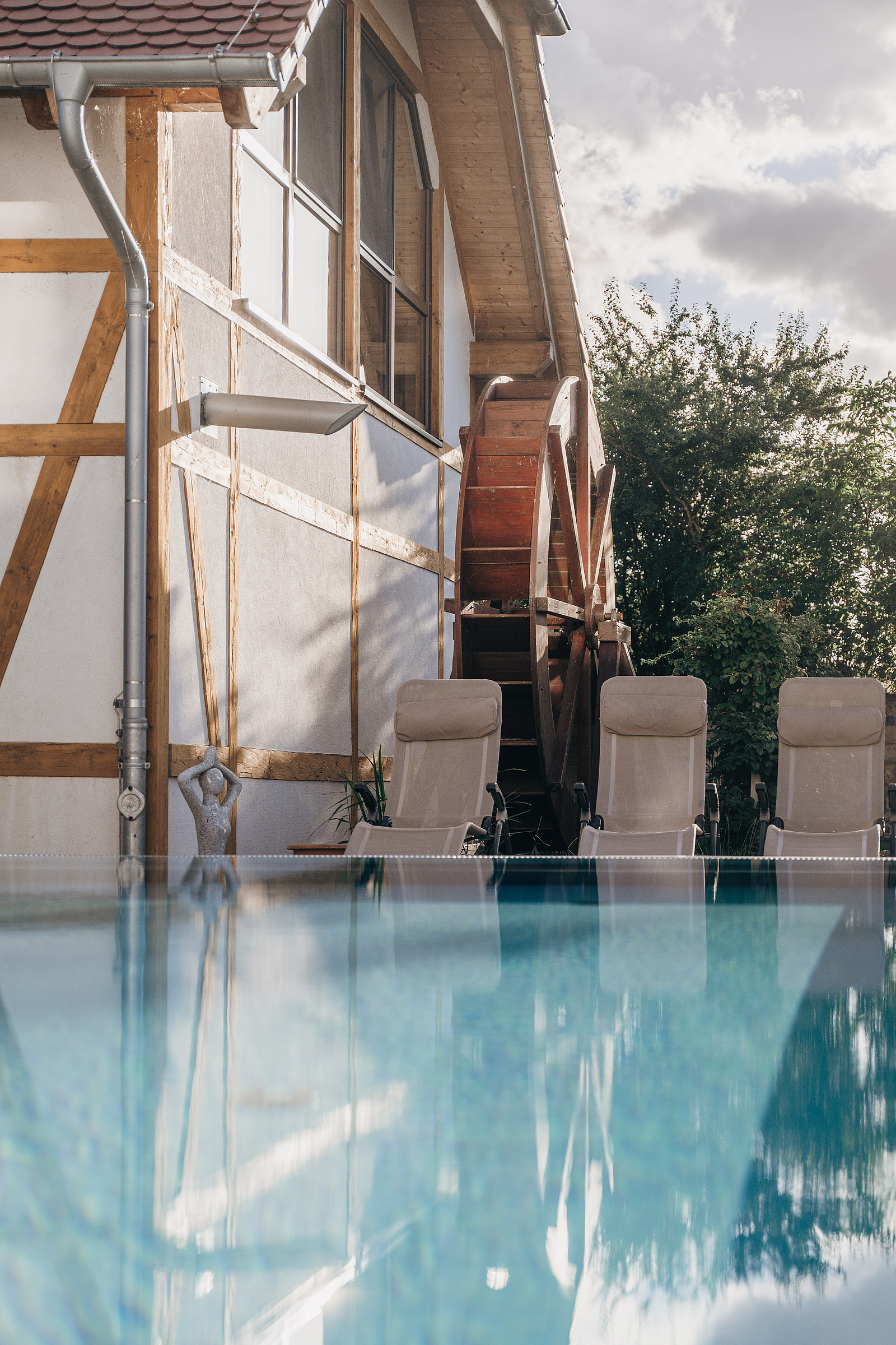 Jordan's Untermühle - Pool mit Fachwerkhaus und Mühlenrad im Hintergrund